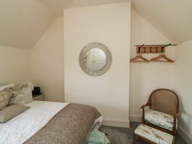 A bedroom with a bed and a chair at 13 School Road in Newton Abbot