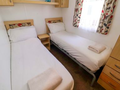 A bedroom with two single beds and a nightstand at 21 Poplar Avenue Felixstowe Suffolk