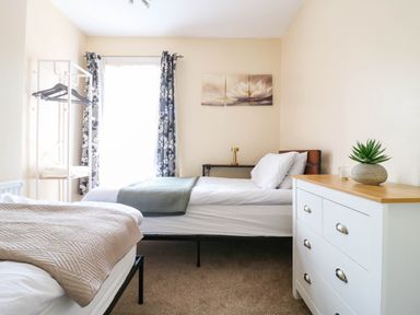 A bedroom with two beds and a dresser at Dover Retreat