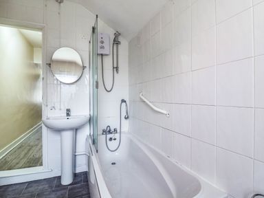 A bathroom with a bathtub, sink, and mirror at Dover Retreat in 