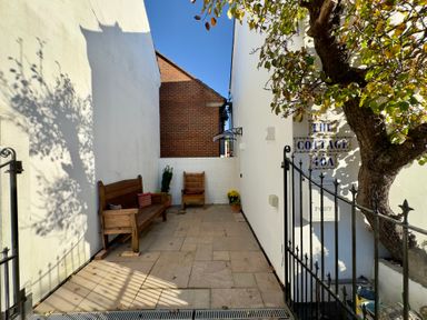 A patio area with wooden seating at The Cottage in Bournemouth