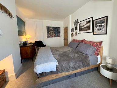 A bedroom with a bed and artwork on the walls at Bohemian Beach Cottage in Bournemouth