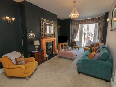 A living room with sofas and a fireplace at Stanton House - Abbey View, Flat 3