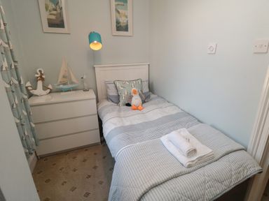 A bedroom with a single bed and a dresser at Stanton House - Abbey View, Flat 3