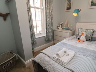 A bedroom with a bed and dresser at Stanton House - Abbey View, Flat 3