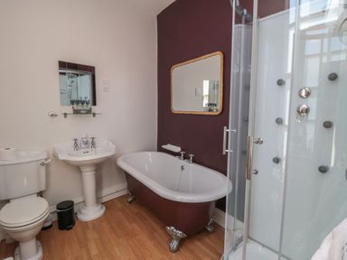 A bathroom with a bathtub, sink, toilet, and shower at Stanton House - Abbey View, Flat 3