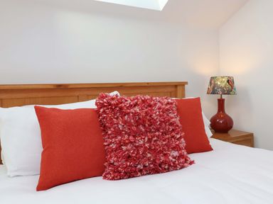 A bedroom with pillows and a lamp at Butterfly Days in Bideford