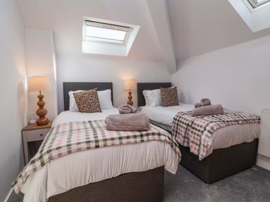 A bedroom with two beds and a lamp at Butterfly Days in Bideford