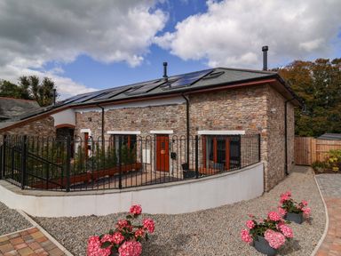 An outdoor view of a stone house with solar panels at Butterfly Days in Bideford