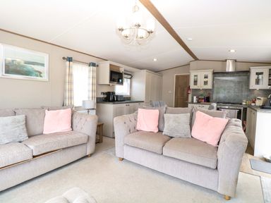 A living room with couches and kitchen area at 17 Castle Walk in Great Yarmouth