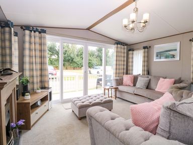 A living room with a sofa and sliding doors at 17 Castle Walk in Great Yarmouth