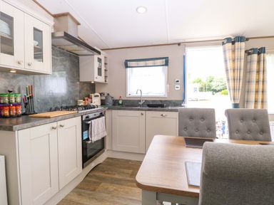 A kitchen with stove, cabinets and table at 17 Castle Walk in Great Yarmouth