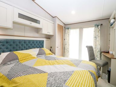 A bedroom with a bed and a chair at 17 Castle Walk in Great Yarmouth