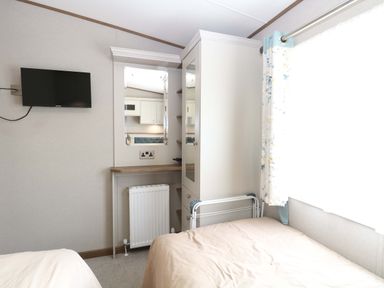 A bedroom with a television and wardrobe at 17 Castle Walk in Great Yarmouth
