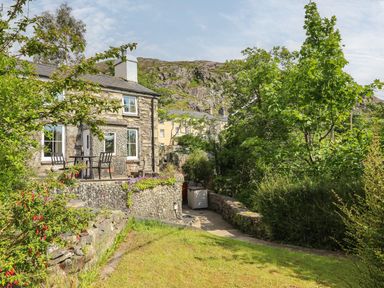 A house with a garden and stone pathway at Brondderwen
