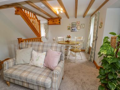 A living room with a sofa and dining table at Brondderwen in Blaenau Ffestiniog