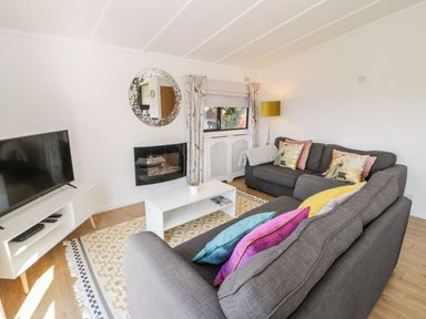 A living room with a sofa and television at Summertime Lodge Rhyd-y-Foel near Abergele