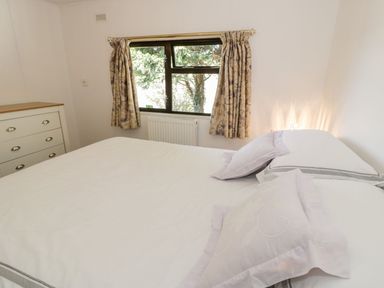 A bedroom with a bed and dresser at Summertime Lodge in Rhyd-y-Foel near Abergele