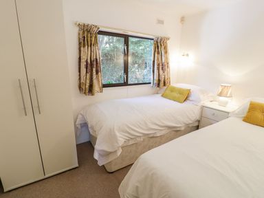 A bedroom with two beds and a window at Summertime Lodge in Rhyd-y-Foel near Abergele