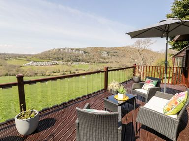 A deck area with chairs and a table at Summertime Lodge Rhyd-y-Foel near Abergele