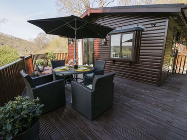 An outdoor patio with a table and chairs at Springtime Lodge Rhyd-y-Foel near Abergele