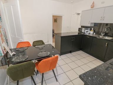 A kitchen with a dining table and chairs at Raglan Lodge in Monmouth