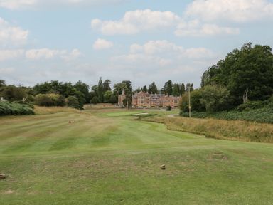 A golf course with grass and trees at Raglan Lodge in Monmouth