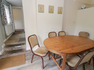 A dining room with a wooden table and chairs at Hillside Cottage