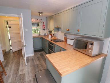 A kitchen with cabinets and appliances at Hillside Cottage