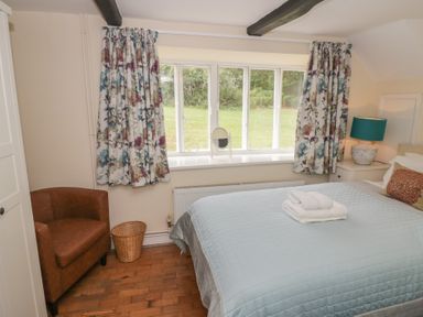 A bedroom with a bed and window at Hillside Cottage