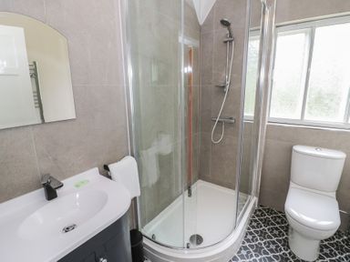 A bathroom featuring a shower, toilet, and sink at Hillside Cottage