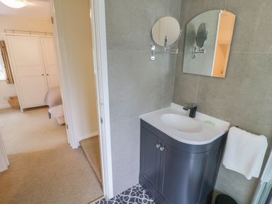 A bathroom with a sink and a mirror at Hillside Cottage