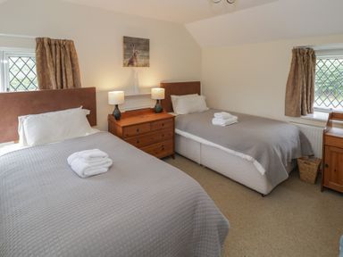 A bedroom with two beds and a dresser at Hillside Cottage