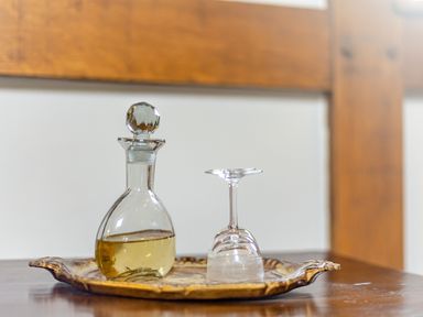 A glass decanter with liquid and an upside down glass on a wooden tray at The Cider Mill in Westhope near Leominster