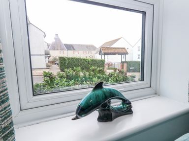 A decorative dolphin sculpture in a window at 23 The Maltings Weymouth