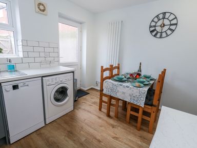 A kitchen with a dining table set with plates at 23 The Maltings in Weymouth