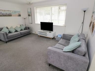 A living room with a sofa and TV at Chalet 26 in Scurlage