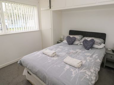 A bedroom with a bed and pillows at Chalet 26 in Scurlage