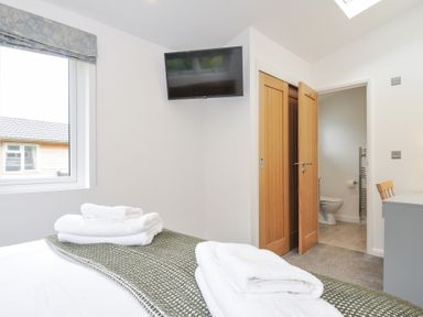 A bedroom with a bed and television at 3 Meadow Retreat in Liskeard