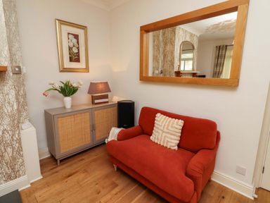 A living room with a sofa and a lamp at Rose Briar Cottage in Morpeth