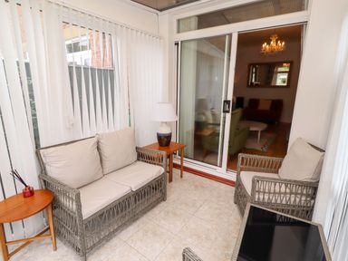 A conservatory with seating and a lamp at Rose Briar Cottage in Morpeth