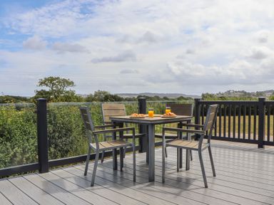 An outdoor dining area with a table and chairs at Maple Lodge in Teigngrace near Kingsteignton