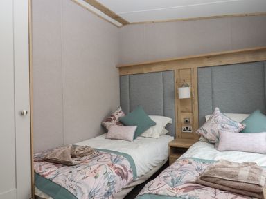 A bedroom with two beds and pillows at Maple Lodge Teigngrace near Kingsteignton