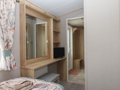 A bedroom with a mirror and shelf at Maple Lodge Teigngrace near Kingsteignton