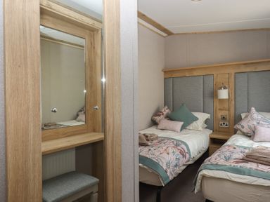 A bedroom with two beds and a mirror at Maple Lodge Teigngrace near Kingsteignton