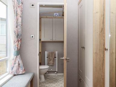 A bathroom with a toilet and towel rack at Maple Lodge Teigngrace near Kingsteignton