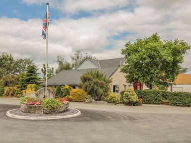 A building with a flag and landscaped area at Maple Lodge Teigngrace near Kingsteignton