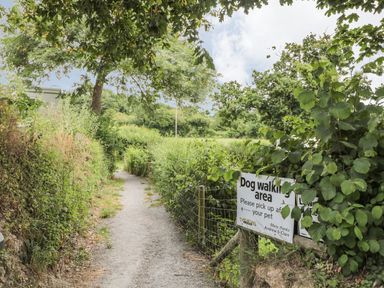 A path with a dog walking area sign at Maple Lodge Teigngrace near Kingsteignton