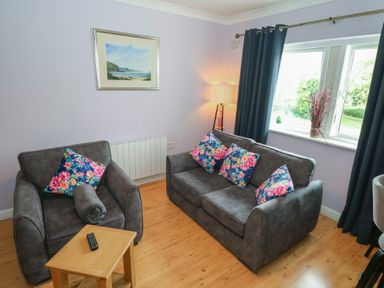 A living room with a sofa and armchair at Kathleens Cosy Apartment in Galway