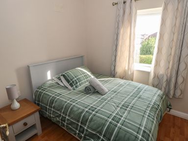 A bedroom with a bed and bedside table at Kathleens Cosy Apartment in Galway